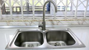 a stainless steel sink in a kitchen with a window at Tropical Oasis in Accra - 2 Bedroom Apartment in Accra