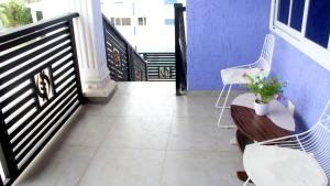 un balcón con 2 sillas y una mesa con flores. en Beautiful 2-Bed Apartment in Accra en Accra