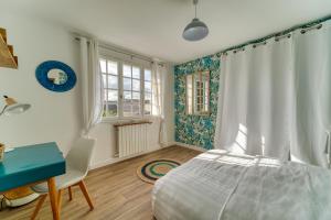 a bedroom with a bed and a desk and a window at Chic and modern house with parking garden and gym in Saint-Denis