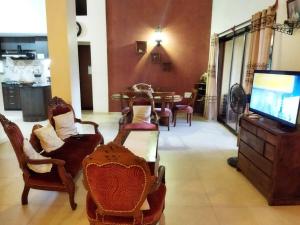 a living room with chairs and a tv and a table at 3BHK Luxury House near Calangute/Bagha(C4) in Anjuna