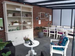 a patio with a table and chairs and a brick wall at B&B Bourgondisch Lomm in Lomm