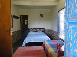 a bedroom with a bed and a window at Pousada Pé da Mata in Aiuruoca