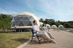 duas mulheres sentadas numa cadeira em frente a uma cúpula em TADAYOI - Sea Glamping - Vacation STAY 42102v 