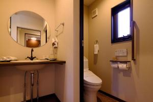 W łazience znajduje się umywalka, toaleta i lustro. w obiekcie Sense of wonder Yufudake Sanroku Glamping Resort - Vacation STAY 41962v w mieście Yufu