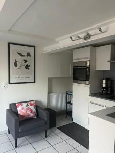 a living room with a chair and a kitchen at kleine Flora - Apartment in Minden