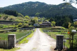 un camino de tierra con una valla y montañas al fondo en Bunko Stay Haruhi - Vacation STAY 42139v, 