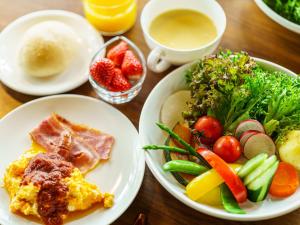 een houten tafel met borden eten en fruit bij Sense of wonder Yufudake Sanroku Glamping Resort - Vacation STAY 41961v in Yufu