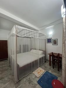 una cama con dosel en una habitación en Gangu Guest House Unawatuna, en Unawatuna 30 fotos más