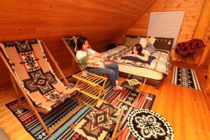 two women sitting on beds in a room with chairs at Kuruma Asobi Adventure Field Appi - Camp - Vacation STAY 42096v in Hachimantai
