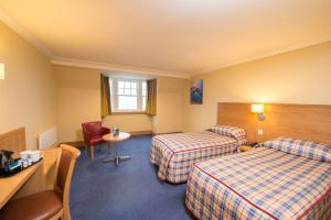 a hotel room with two beds and a table at Ardgartan Hotel in Arrochar