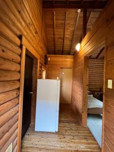 un frigorifero al centro di una stanza con pareti in legno di Nasu Takahara Auto Campsite - Vacation STAY 42064v a Nasushiobara