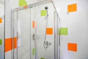 a shower with orange and green squares on the wall at Spacious Duplex Apartment in the heart of Porto in Porto