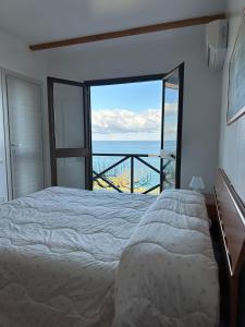 a bedroom with a bed and a view of the ocean at Mareblu B&B in Cefalù