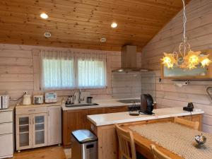 a kitchen in a log cabin with a wooden ceiling at Camp inn Kiyosato GRANDEUR - Vacation STAY 42082v in Hokuto