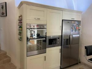 a kitchen with a stainless steel refrigerator and cabinets at La Stala in Pieve di Teco