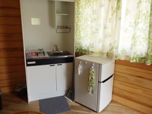 a small kitchen with a refrigerator and a sink at Ayu no Sato Park Campsite - Vacation STAY 42154v in Shōbara