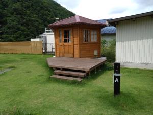 Cabaña de madera con terraza en un patio en Ayu no Sato Park Campsite - Vacation STAY 42154v en Shōbara