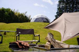 une table avec une tente et deux chaises sur un champ dans l'établissement Kannami Springs Hotel Kannami Glamping - Camp - Vacation STAY 62738v, à Mishima