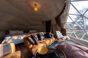 中津川市にあるHoko Glamping- Camp - Vacation STAY 51101vのソファとテント内のベッド1台が備わる客室です。