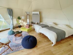 三島市にあるKannami Springs Hotel Kannami Glamping - Camp - Vacation STAY 62739vのラグ付きの部屋にベッド2台が備わるベッドルーム1室が備わります。