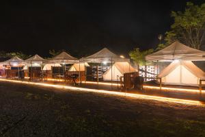 une rangée de tentes éclairées la nuit dans l'établissement SPRINGS VILLAGE Ashigara-Tanzawa Hot Spring Resort & Glamping - Vacation STAY 42311v, à Oyama