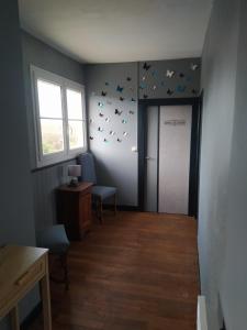 korytarz z drzwiami z motylami na ścianie w obiekcie grand gîte à la campagne w mieście Couvains