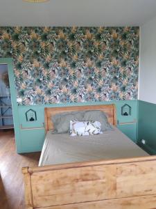 a bedroom with a bed with a floral wallpaper at grand gîte à la campagne in Couvains +22 photos