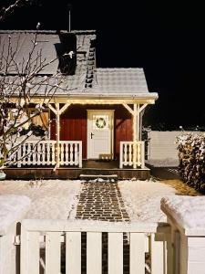 una piccola casa con una recinzione bianca di fronte di Ostseeklang a Zingst