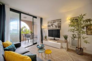 a living room with a couch and a tv at Tim - 2min de la mer - Piscine - Terrasse - VCA in Cannes