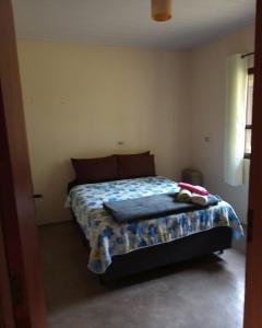a bedroom with a bed with a blanket on it at Casinha nas montanhas in Gonçalves
