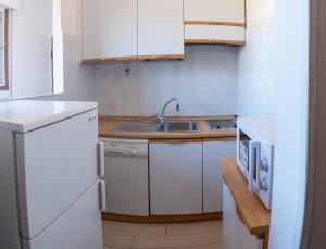 a kitchen with white cabinets and a sink at il Golfo di Diana in Diano Marina