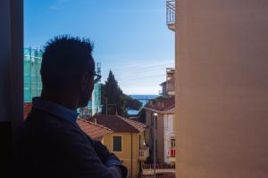 a man looking out a window at a city at il Golfo di Diana in Diano Marina