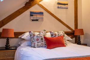 1 dormitorio con 1 cama con sábanas y almohadas blancas en The Garret, en Salisbury