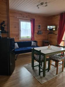 sala de estar con mesa y sofá azul en Chalet au coeur du parc du Morvan - Moux-en-Morvan, en Moux-en-Morvan