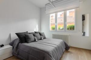 a bedroom with a large bed and two windows at La dimora degli asinelli in Bologna
