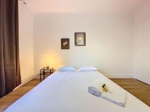ein Schlafzimmer mit einem weißen Bett und einem goldenen Schlüssel darauf in der Unterkunft Cosy Appartement, Lyon 6è Barrier in Lyon