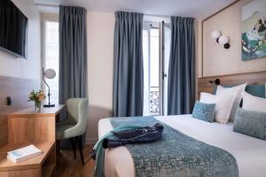 a hotel room with a bed and a desk at Dream Hôtel Opéra & Spa in Paris