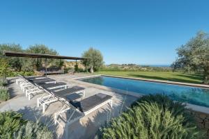 una piscina con tumbonas y un pabellón en Villa Vogue - IsulaTravel, en Avola