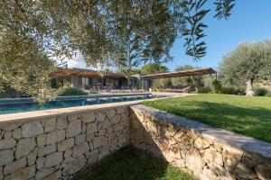 una casa con una pared de piedra y una piscina en Villa Vogue - IsulaTravel, en Avola
