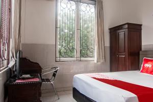 una camera con letto, scrivania e finestra di OYO 93499 Pondok Sentosa Near UPH a Giacarta