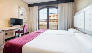 Una habitación de hotel con una cama, un escritorio y una ventana. en Ilunion Golf Badajoz, en Badajoz 30 fotos más