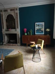 a living room with a blue wall and a table and chairs at Grande maison #6 chambres #Proche Amboise/Tours in Mosnes