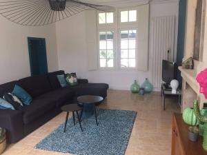 a living room with a black couch and two tables at Grande maison #6 chambres #Proche Amboise/Tours in Mosnes