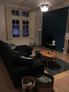 a living room with a black couch and a table at Grande maison #6 chambres #Proche Amboise/Tours in Mosnes +42 photos