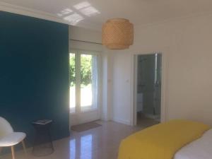 1 dormitorio con cama amarilla y pared azul en Grande maison #6 chambres #Proche Amboise/Tours, en Mosnes