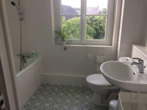 baño con lavabo y aseo y ventana en Grande maison #6 chambres #Proche Amboise/Tours en Mosnes