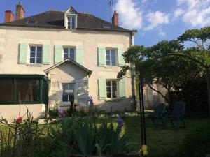 uma casa com persianas verdes e cadeiras no quintal em Grande maison #6 chambres #Proche Amboise/Tours em Mosnes