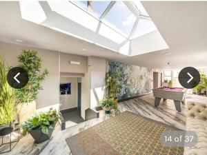 a skylight in a living room with potted plants at Immaculate 6-Bed Ivy house in Doncaster