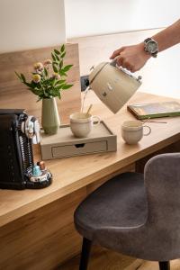 a person is pouring coffee into a cup on a desk at Hôtel Théorème in Paris