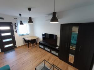 uma sala de estar com uma mesa e uma televisão em Apartmani Jana em Osijek